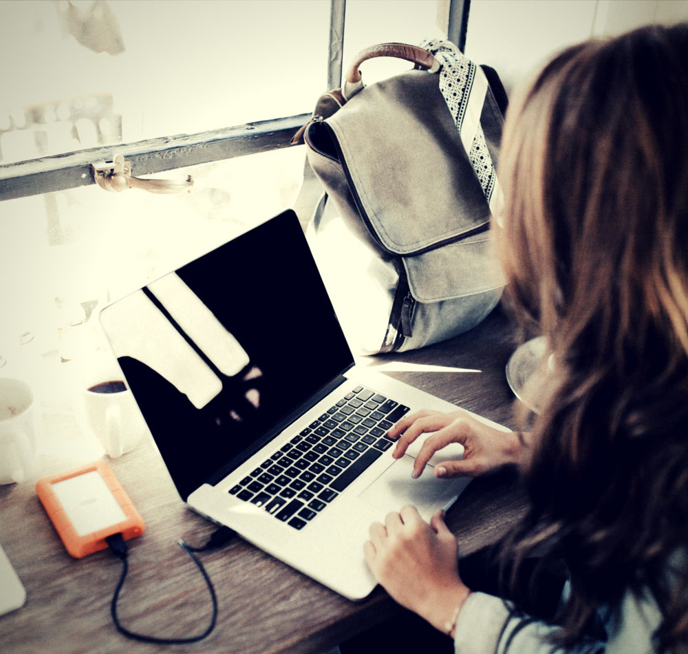 woman working on laptop at counter by the window